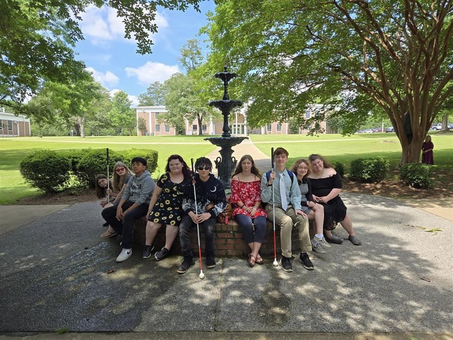   Nine students seated around an outdoor fountain during a 4-H Regional Congress Meeting. 